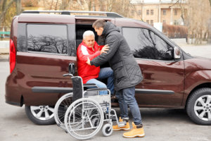 caregiver assist his patient in stepping out the car