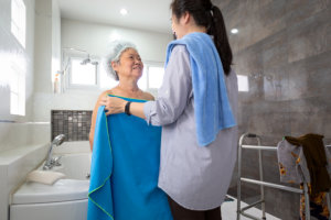 caregiver assist her patient in taking a bath