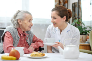 caregiver assist her patient in eating breakfast